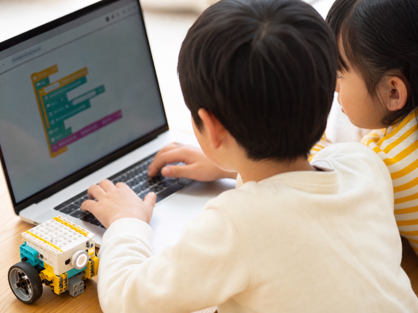 パソコンとロボット教材で学ぶ子どもたちの後ろ姿